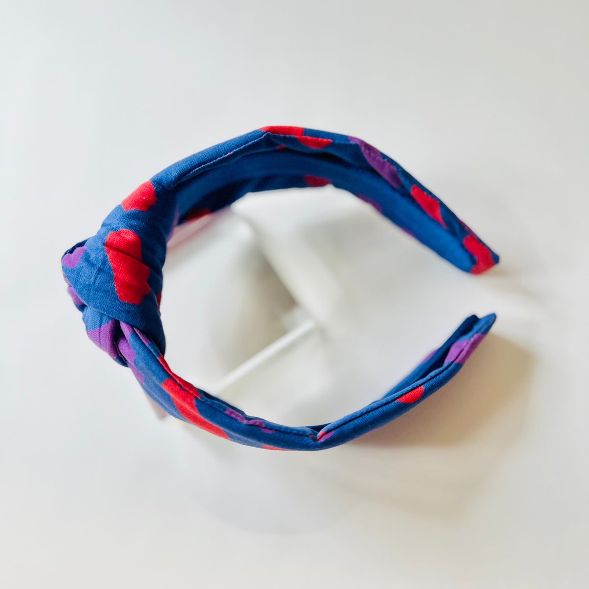 Blue and red patterned headband on a white background