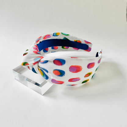 Colorful polka dot headband on a white background