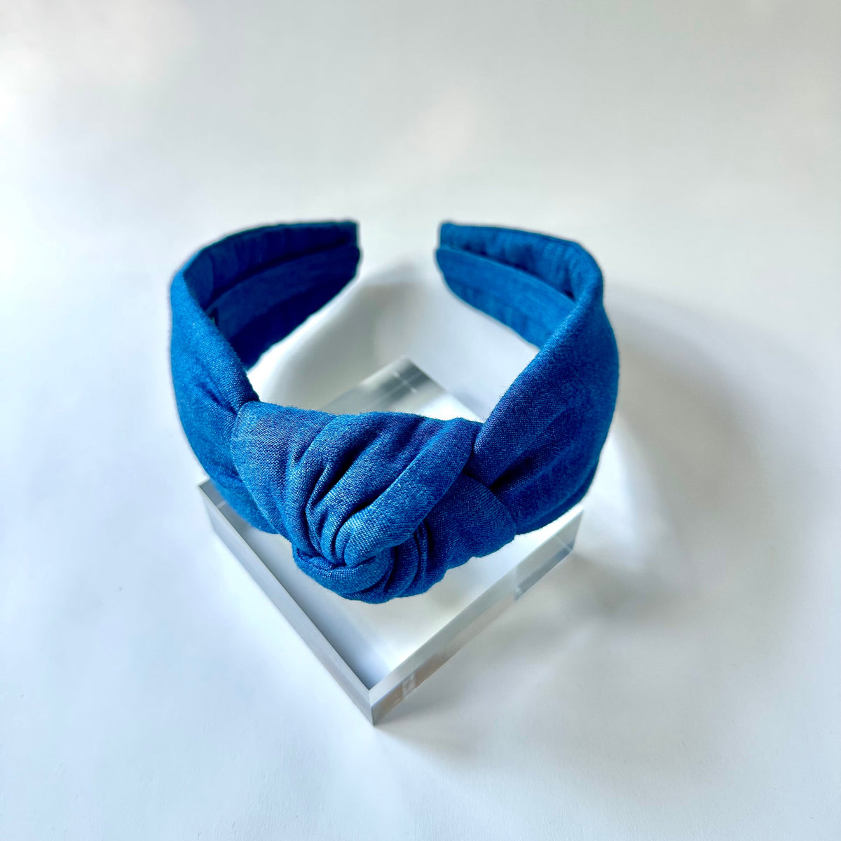 Blue headband on a white stand with a white background