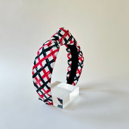 Plaid headband on a white stand against a light gray background