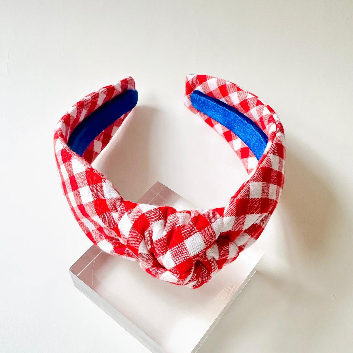 Red and white checkered headband with blue interior on a white background