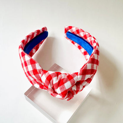 Red and white checkered headband with blue interior on a white background