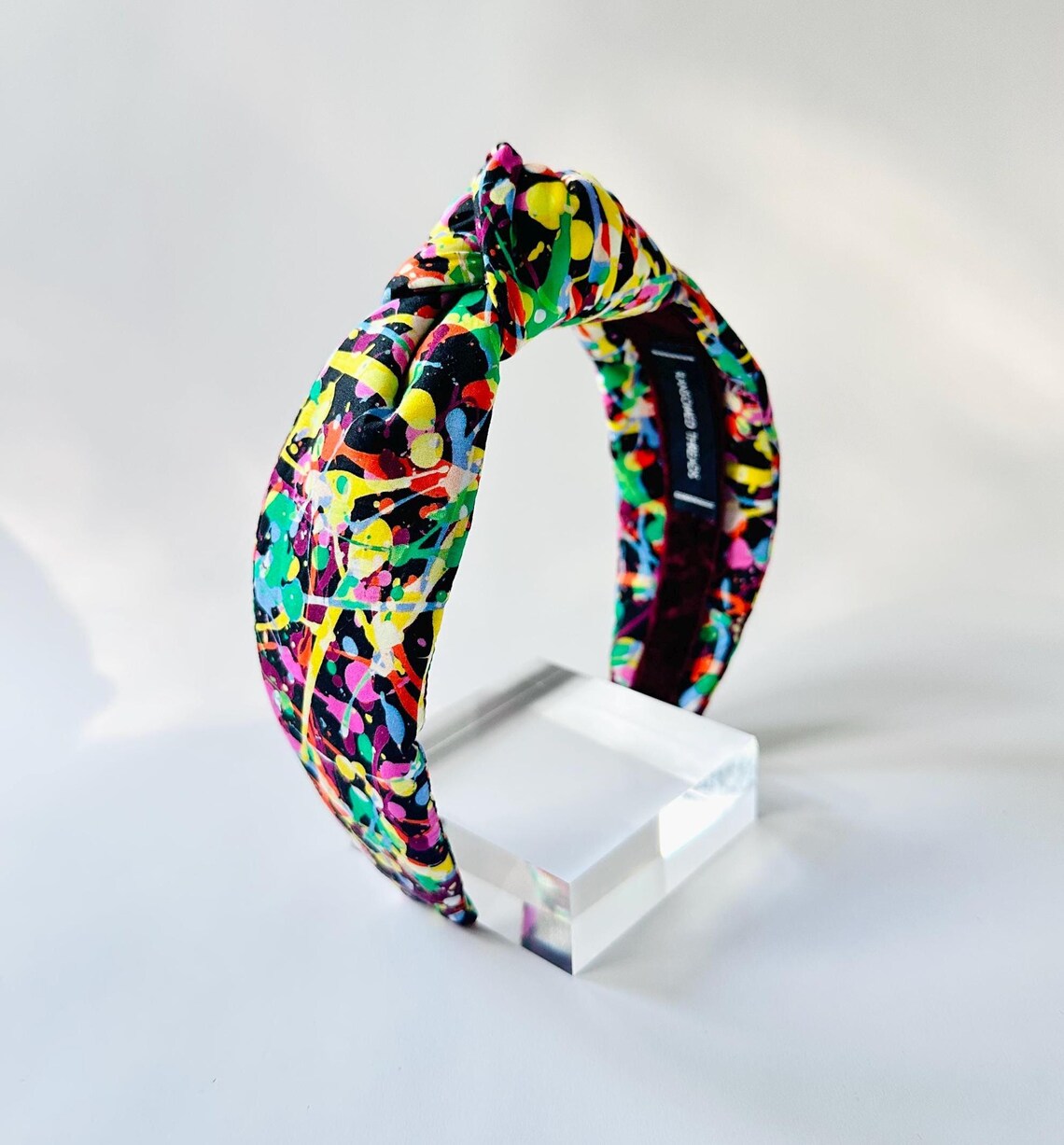 Colorful headband with a black background on a white stand